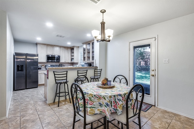 tiled dining area with an inviting chandelier