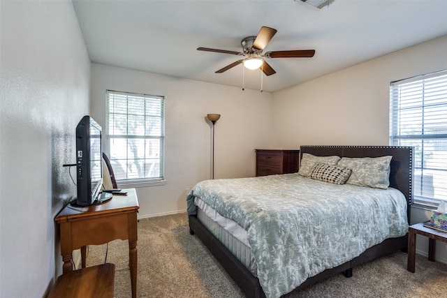 carpeted bedroom featuring ceiling fan and multiple windows