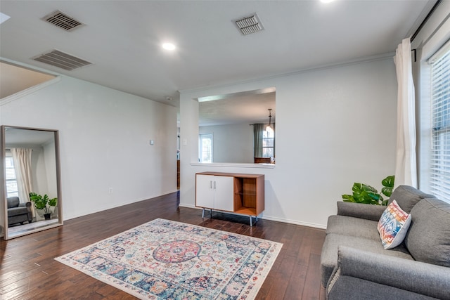 living room with dark wood-type flooring and ornamental molding