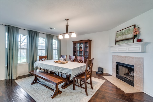 dining space featuring hardwood / wood-style flooring and a tile fireplace