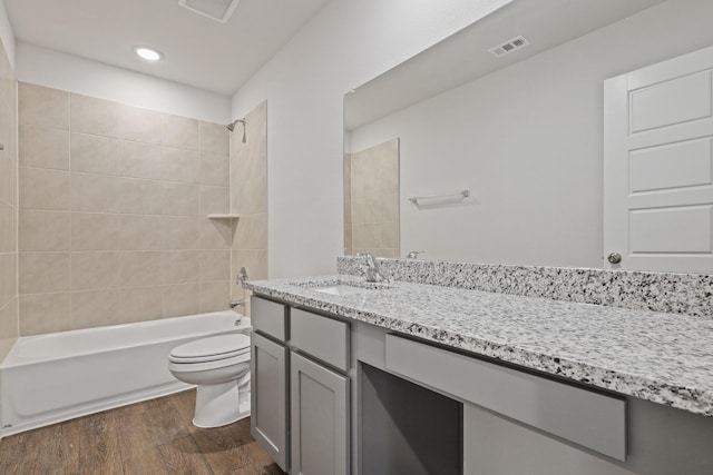 full bathroom featuring shower / bathtub combination, visible vents, toilet, vanity, and wood finished floors