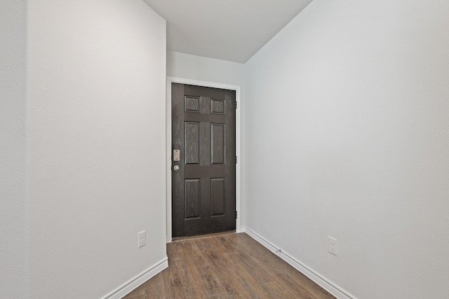 unfurnished room with dark wood-style floors and baseboards