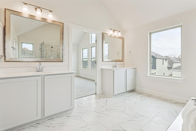 bathroom with a shower, vanity, a healthy amount of sunlight, and vaulted ceiling