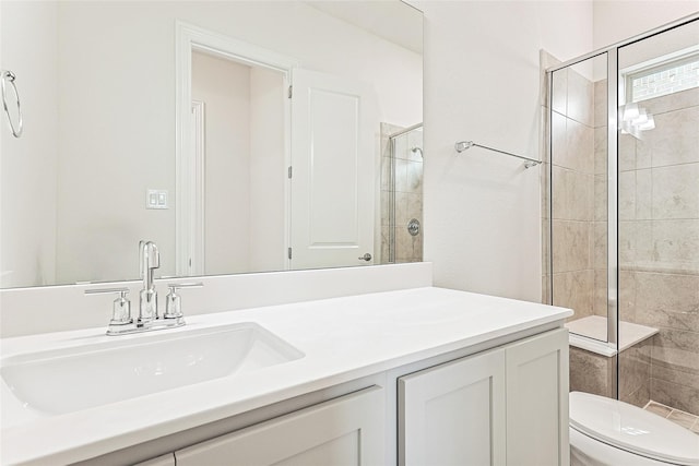 bathroom with a shower with door, vanity, and toilet