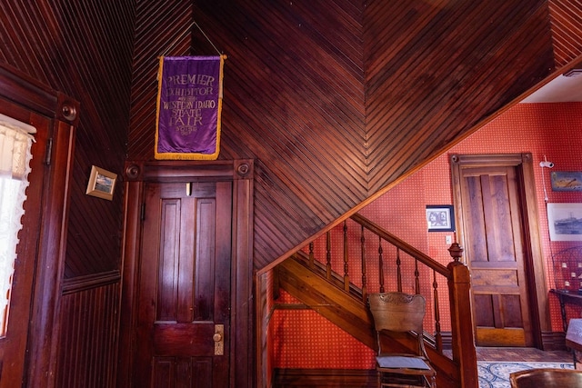 staircase featuring wooden walls