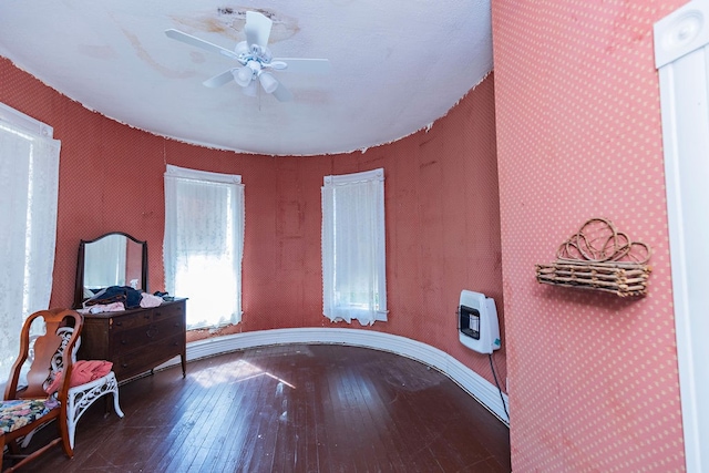 office space featuring wood-type flooring, heating unit, and ceiling fan