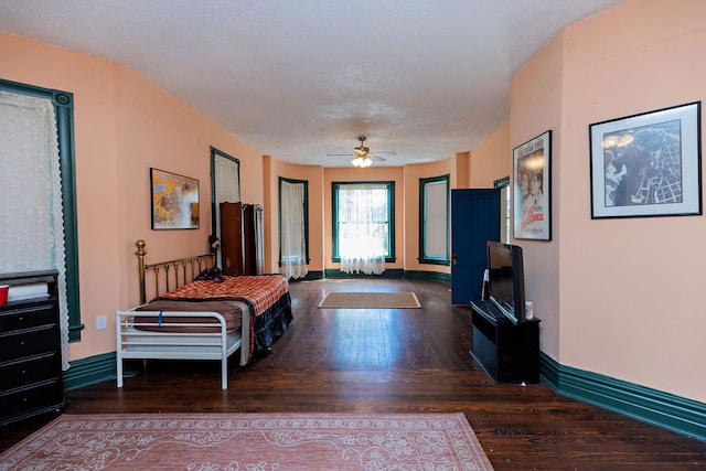 bedroom featuring a textured ceiling, ceiling fan, and dark hardwood / wood-style flooring