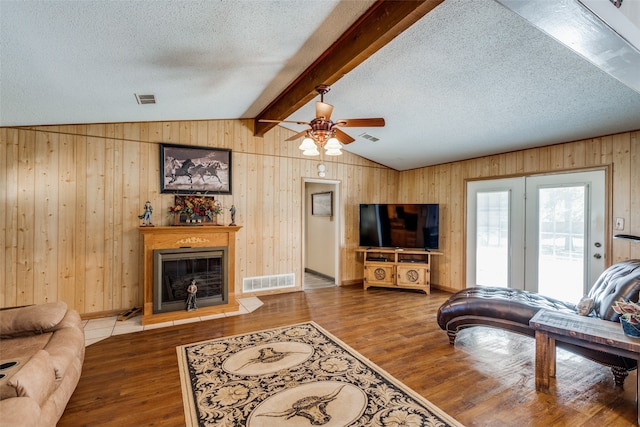 living room featuring ceiling fan, lofted ceiling with beams, wood-type flooring, and a textured ceiling