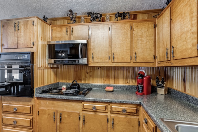 kitchen featuring black appliances and a textured ceiling