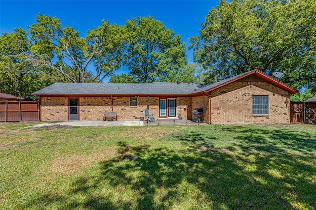 back of house with a lawn and a patio