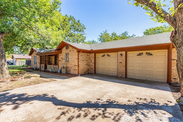 ranch-style home featuring covered porch and a garage