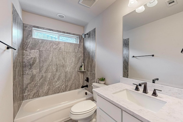 full bathroom with tiled shower / bath, vanity, and toilet