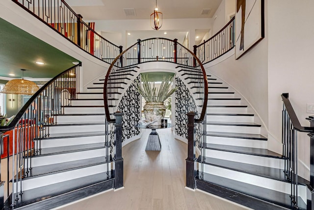 staircase featuring a high ceiling and hardwood / wood-style floors