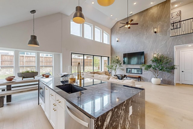 kitchen featuring appliances with stainless steel finishes, decorative light fixtures, white cabinetry, and dark stone countertops