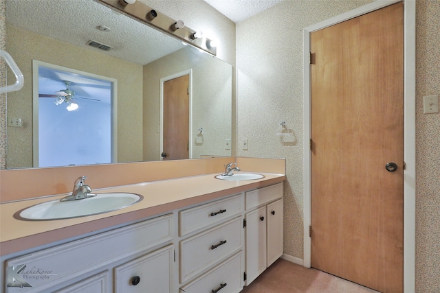 bathroom featuring ceiling fan, vanity, and a textured ceiling