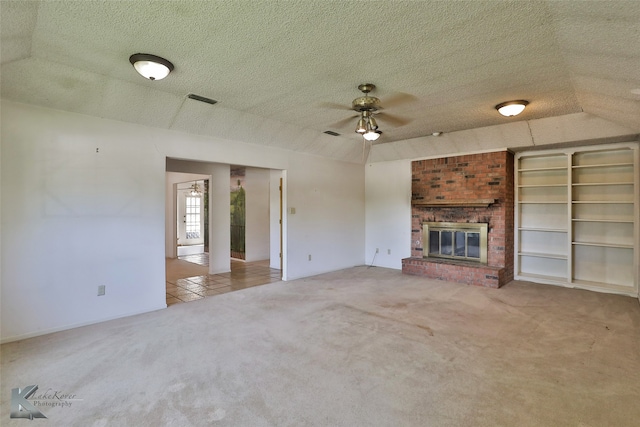 unfurnished living room with carpet floors, a fireplace, a textured ceiling, and ceiling fan