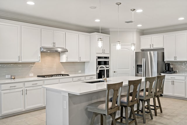 kitchen with stainless steel appliances, sink, decorative light fixtures, a center island with sink, and white cabinetry