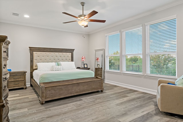 bedroom featuring light wood-type flooring, ceiling fan, and ornamental molding