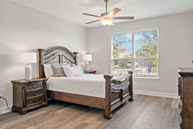 bedroom featuring hardwood / wood-style floors, ceiling fan, and multiple windows