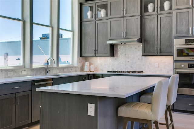 kitchen featuring a kitchen island, stainless steel appliances, sink, and a breakfast bar area