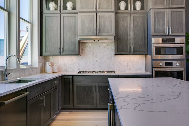 kitchen featuring sink, light stone countertops, and appliances with stainless steel finishes