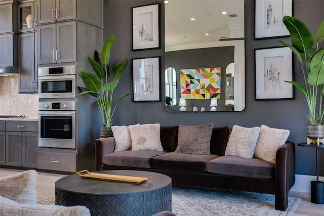 living room featuring crown molding and light hardwood / wood-style floors