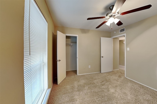 unfurnished bedroom with ceiling fan, light carpet, and a closet