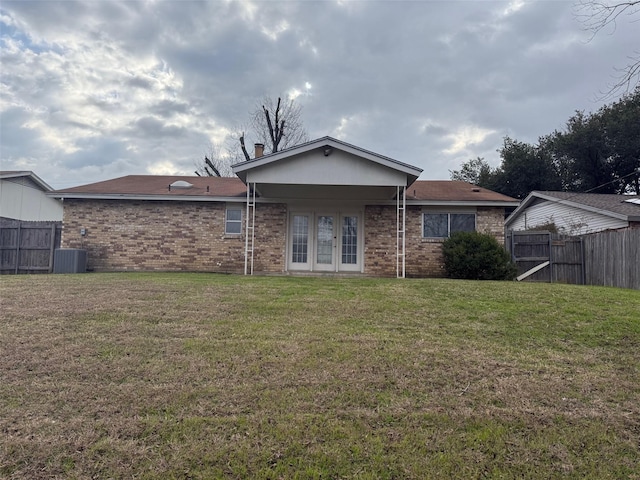 rear view of house with french doors, a yard, and central AC unit