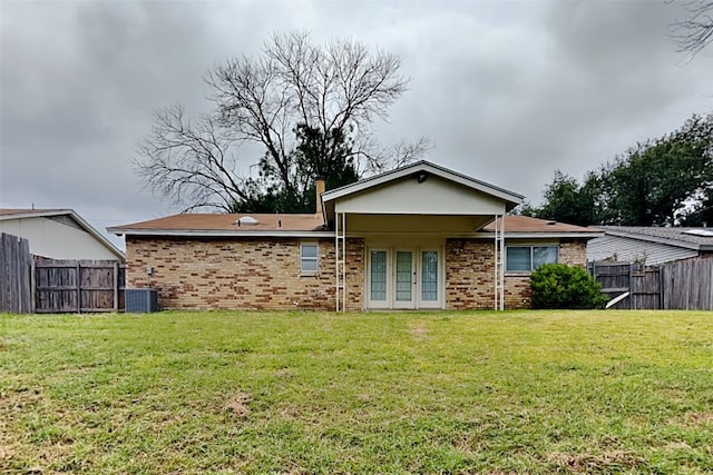 back of property featuring a yard, central AC, and french doors