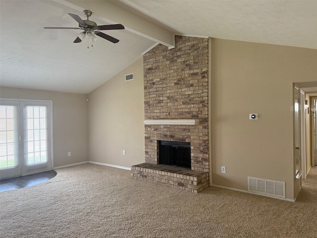 unfurnished living room with vaulted ceiling with beams, carpet floors, a brick fireplace, and ceiling fan