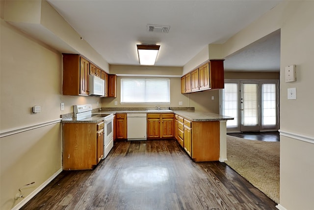 kitchen featuring dark hardwood / wood-style floors, sink, white appliances, and kitchen peninsula