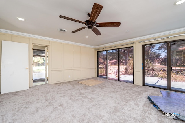 carpeted spare room featuring ceiling fan and crown molding