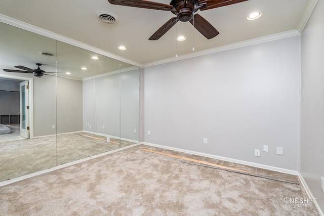 empty room featuring carpet floors, ceiling fan, and crown molding