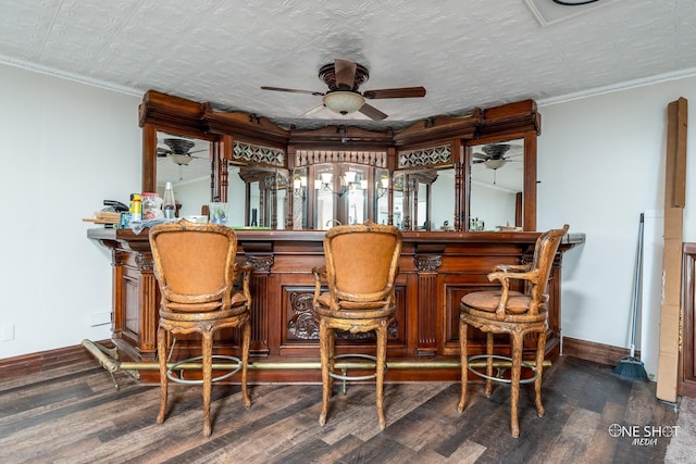 bar with ceiling fan, dark hardwood / wood-style flooring, a textured ceiling, and ornamental molding