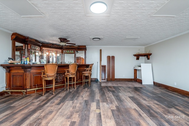 bar with a textured ceiling, dark hardwood / wood-style floors, ceiling fan, and crown molding