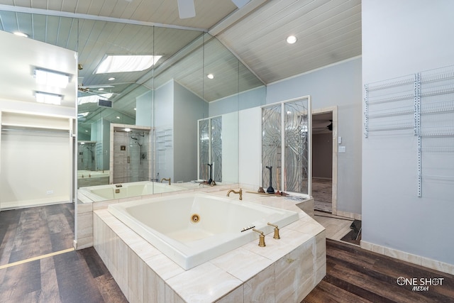 bathroom with wood-type flooring, ceiling fan, independent shower and bath, and vaulted ceiling with skylight