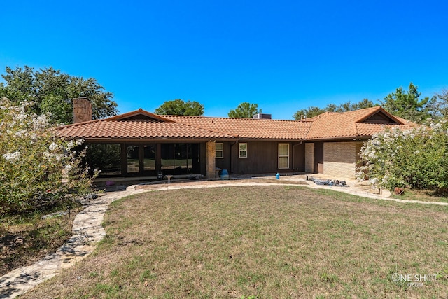 rear view of property featuring a lawn