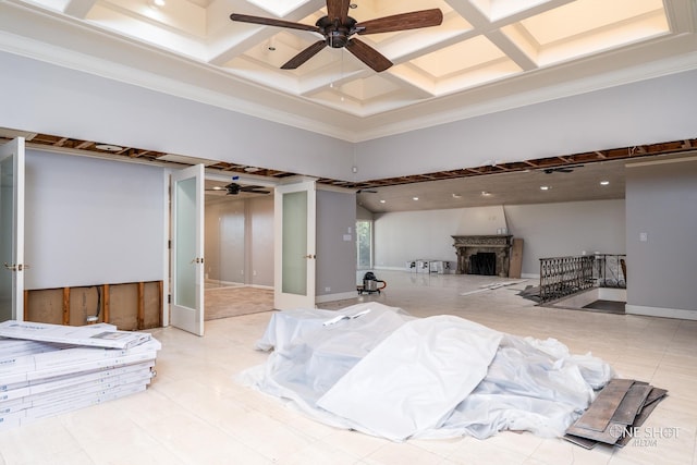 interior space with a fireplace, ornamental molding, a towering ceiling, and coffered ceiling