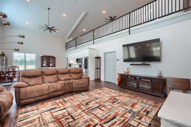 living room with ceiling fan, high vaulted ceiling, and dark hardwood / wood-style flooring