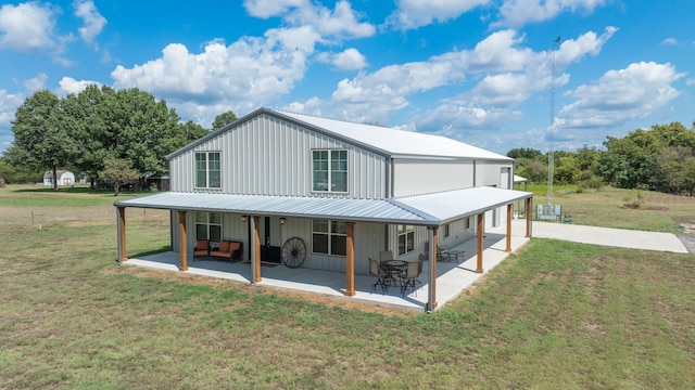 back of house with a patio and a lawn