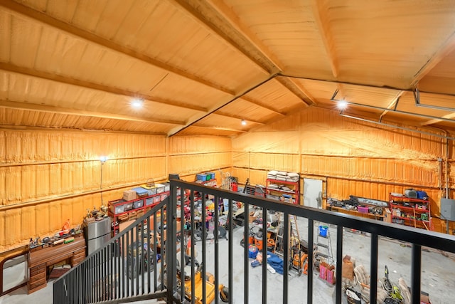 interior space featuring lofted ceiling and wood walls