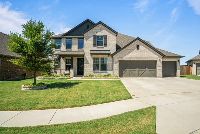 craftsman inspired home featuring a garage and a front lawn