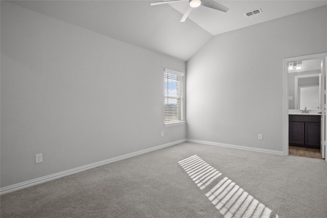 unfurnished bedroom featuring lofted ceiling, sink, ceiling fan, connected bathroom, and light carpet