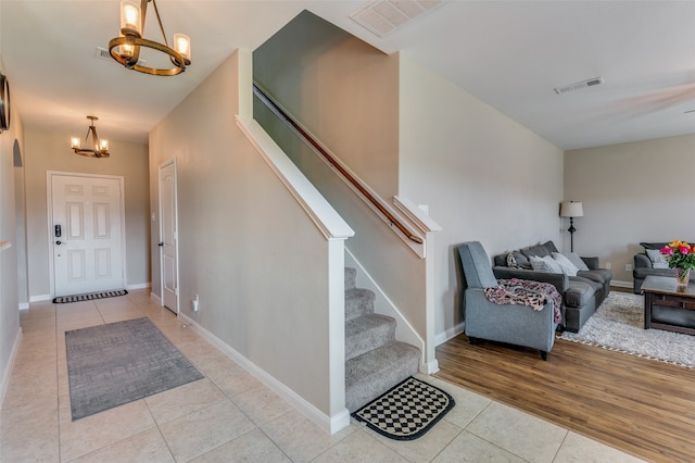 foyer entrance featuring light hardwood / wood-style flooring and an inviting chandelier