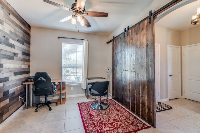 tiled office with a barn door and ceiling fan