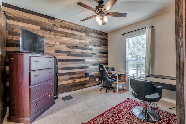 tiled home office featuring ceiling fan and wood walls