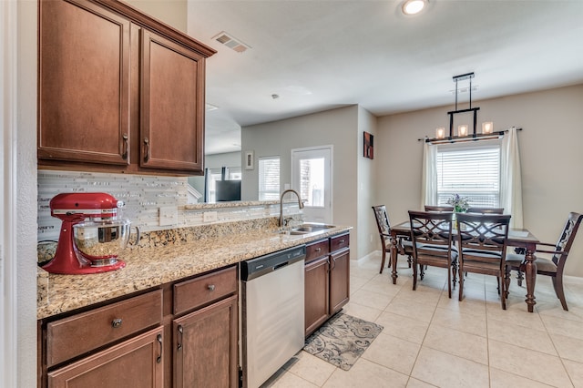 kitchen with tasteful backsplash, dishwasher, light stone counters, sink, and light tile patterned flooring