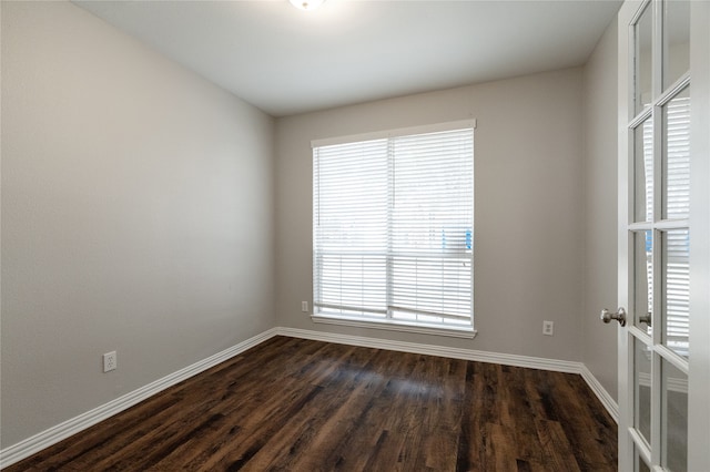 empty room with dark hardwood / wood-style floors and a healthy amount of sunlight