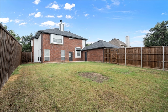 rear view of property with a yard