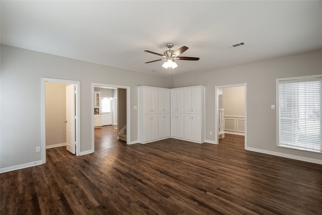 unfurnished bedroom featuring connected bathroom, dark wood-type flooring, a closet, and ceiling fan